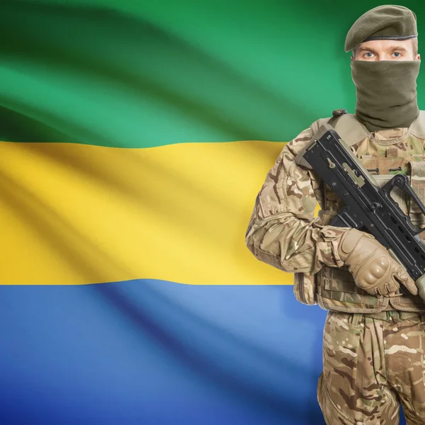 Soldier with machine gun and flag on background - Gabon — Stok Foto