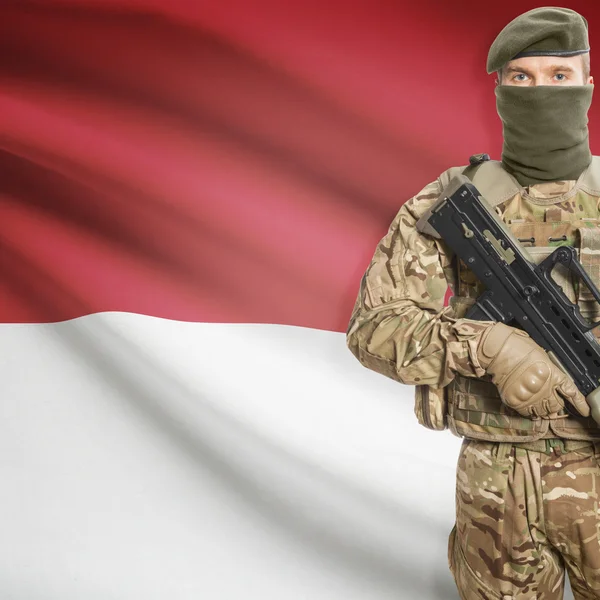 Katona géppuskával és háttér - Monaco zászlót — Stock Fotó