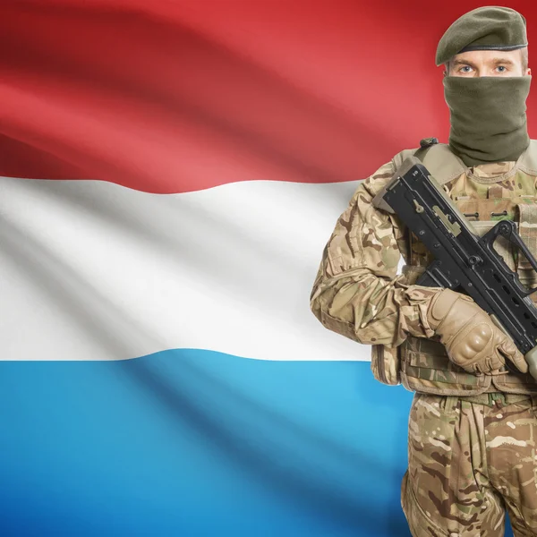 Soldier with machine gun and flag on background - Luxembourg — Stock Photo, Image