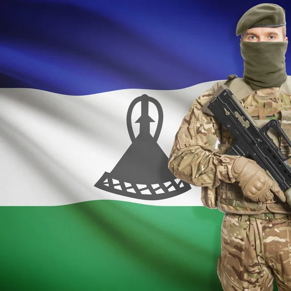 Soldier with machine gun and flag on background - Lesotho – stockfoto