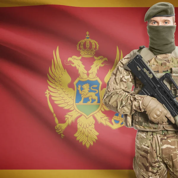 Katona a géppuska és a zászló, a háttér - Montenegró — Stock Fotó