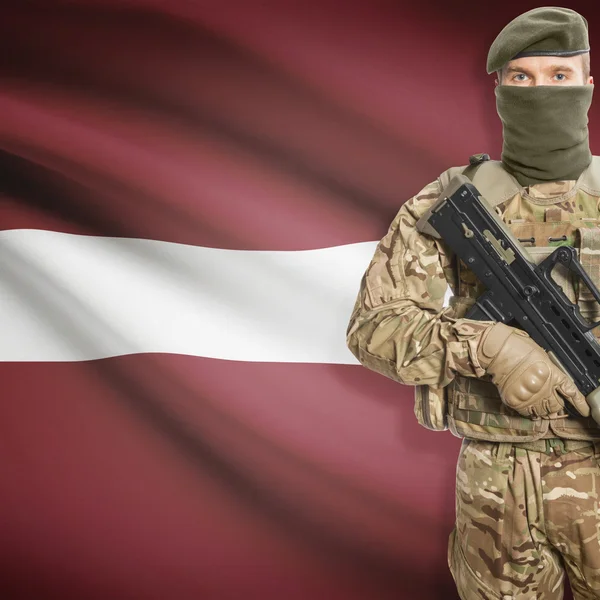Soldier with machine gun and flag on background - Latvia — Stock Photo, Image