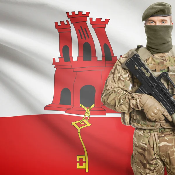 Soldier with machine gun and flag on background - Gibraltar — Stok Foto