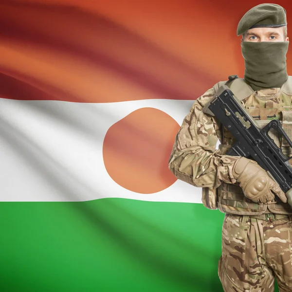 Soldier with machine gun and flag on background - Niger — Stok Foto