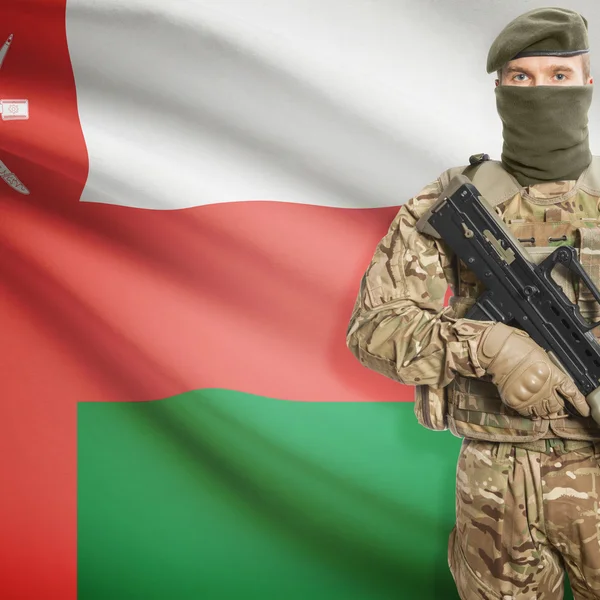 Soldat mit Maschinengewehr und Flagge auf Hintergrund - Oman — Stockfoto