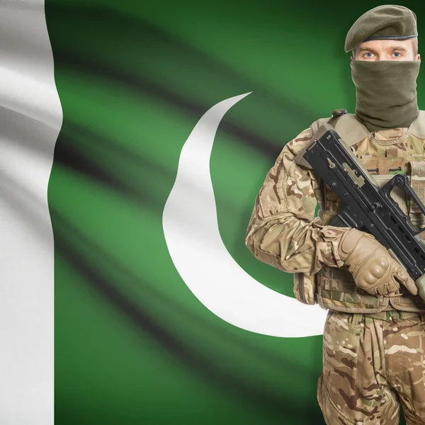 Soldier with machine gun and flag on background - Pakistan — Stock Photo, Image