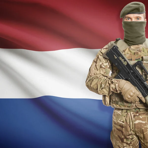 Soldier with machine gun and flag on background - Netherlands — Stock Photo, Image