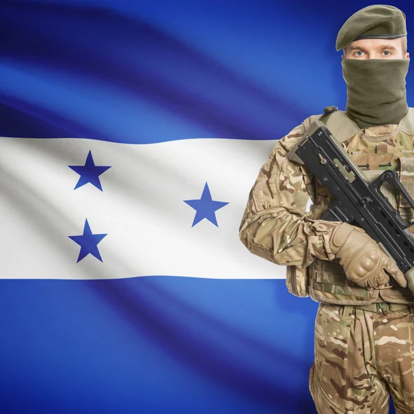 Soldier with machine gun and flag on background - Honduras — Stok Foto