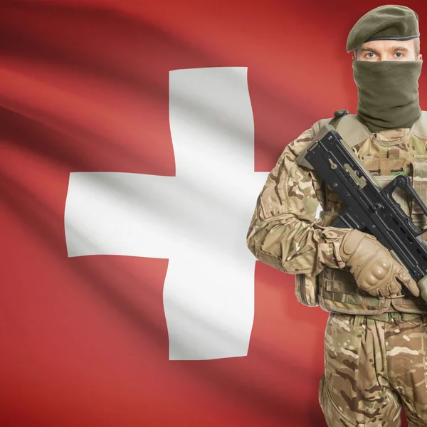 Soldier with machine gun and flag on background - Switzerland — Stock Photo, Image