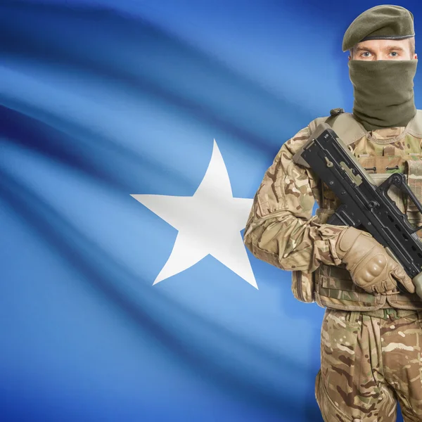 Soldado con ametralladora y bandera en el fondo - Somalia — Foto de Stock