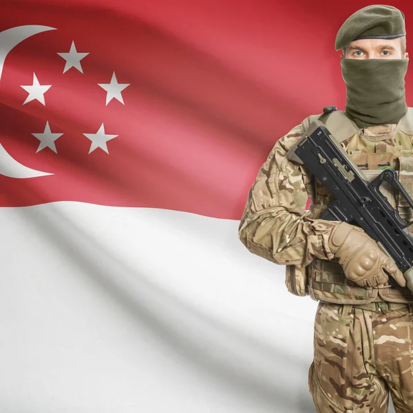 Soldier with machine gun and flag on background - Singapore — Stock Photo, Image