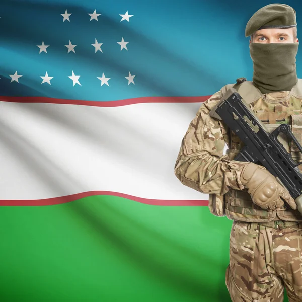 Katona géppuskával és háttér - Üzbegisztán zászlót — Stock Fotó