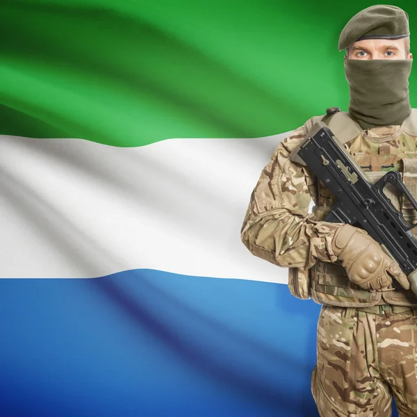 Soldat avec une mitrailleuse et un drapeau sur le fond - Sierra Leone — Photo