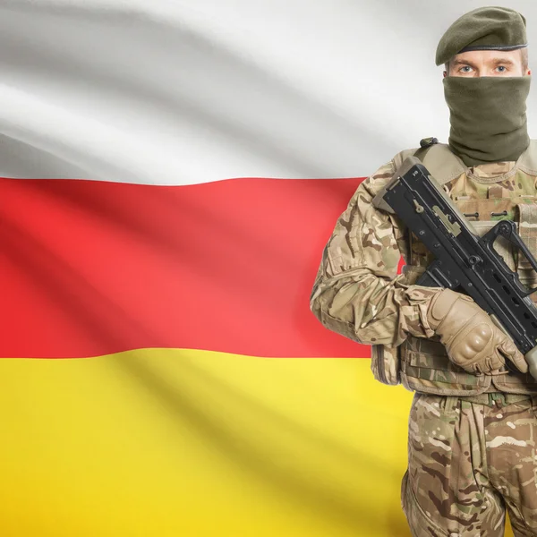 Soldier with machine gun and flag on background - South Ossetia — Stock Photo, Image