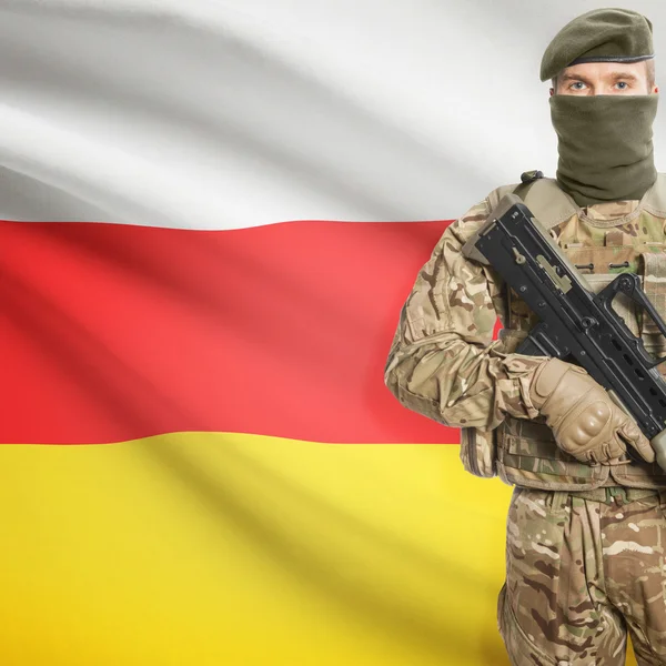 Soldier with machine gun and flag on background - South Ossetia – stockfoto