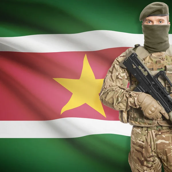Soldier with machine gun and flag on background - Suriname — ストック写真