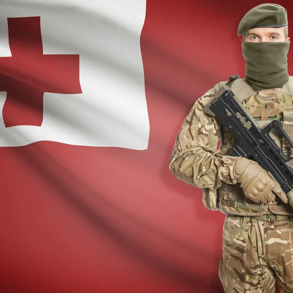 Soldier with machine gun and flag on background - Tonga — Stock Photo, Image