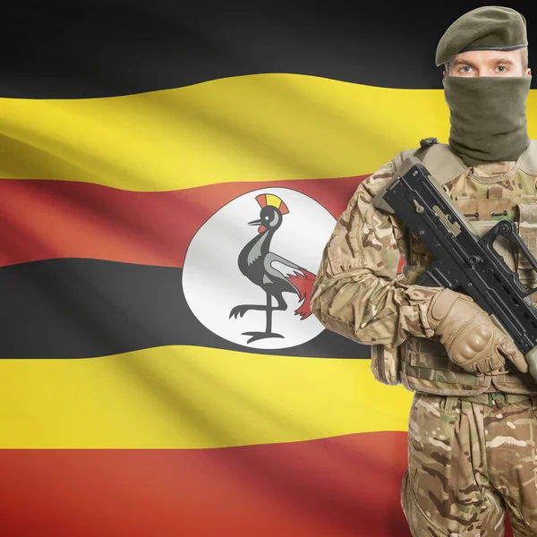 Soldier with machine gun and flag on background - Uganda — ストック写真