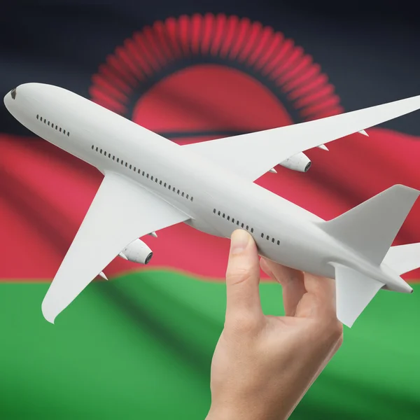 Flugzeug in der Hand mit Flagge auf Hintergrund-Serie - Malawi — Stockfoto