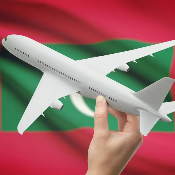 Αεροπλάνο στο χέρι με σημαία επάνω σε φόντο σειρά - Μαλδίβες — Φωτογραφία Αρχείου