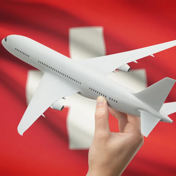 Flugzeug in der Hand mit Flagge auf Hintergrund-Serie - Schweiz — Stockfoto