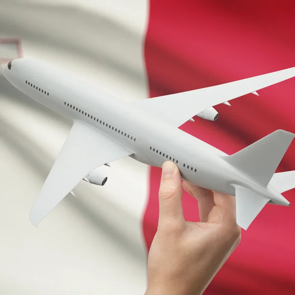 Airplane in hand with flag on background series - Malta — Stock Photo, Image