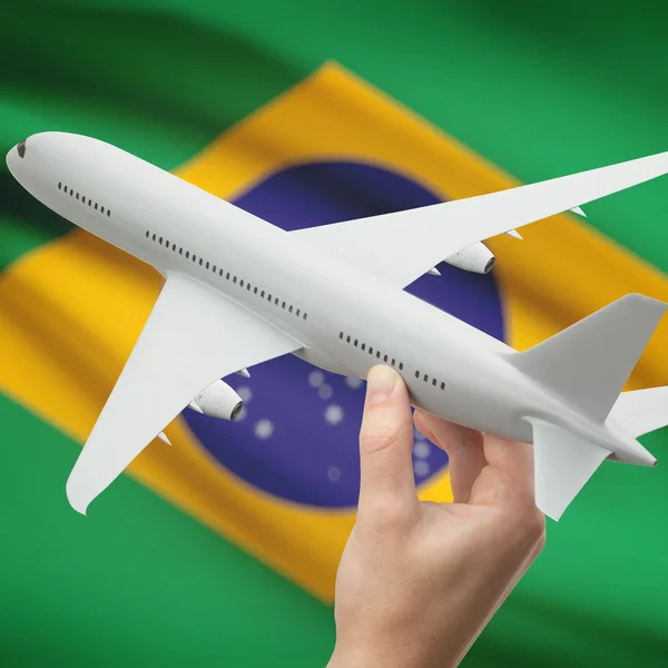 Avión en la mano con la bandera en la serie de fondo - Brasil — Foto de Stock