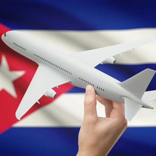 Avión en la mano con la bandera en la serie de fondo - Cuba — Foto de Stock