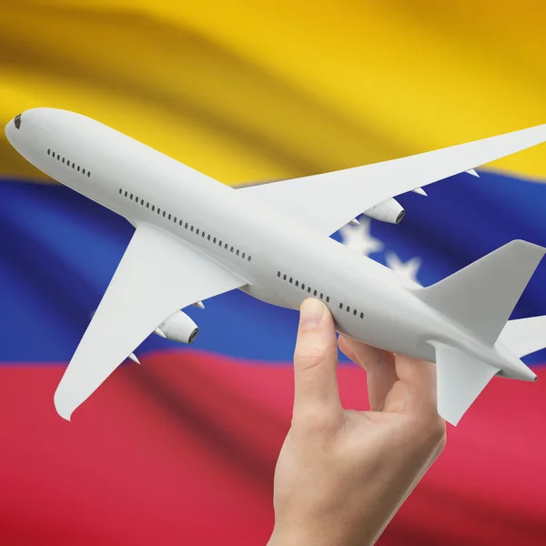 Letadlo v ruce s vlajkou na pozadí řady - Venezuela — Stock fotografie