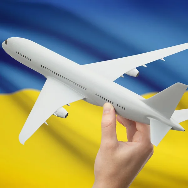 Flugzeug in der Hand mit Flagge auf Hintergrund-Serie - Ukraine — Stockfoto