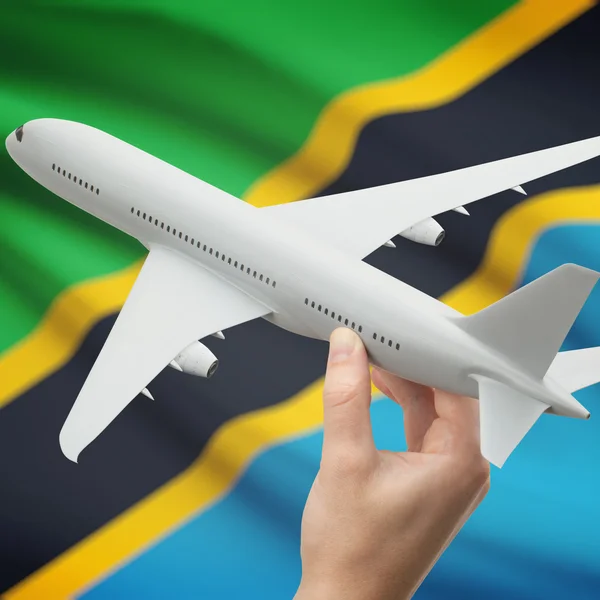 Vliegtuig in hand met vlag op achtergrond serie - Tanzania — Stockfoto