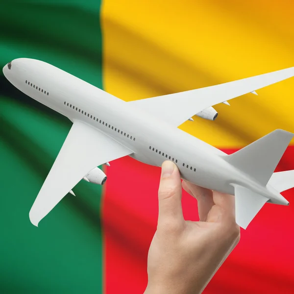 Airplane in hand with flag on background series - Benin — Stock Photo, Image