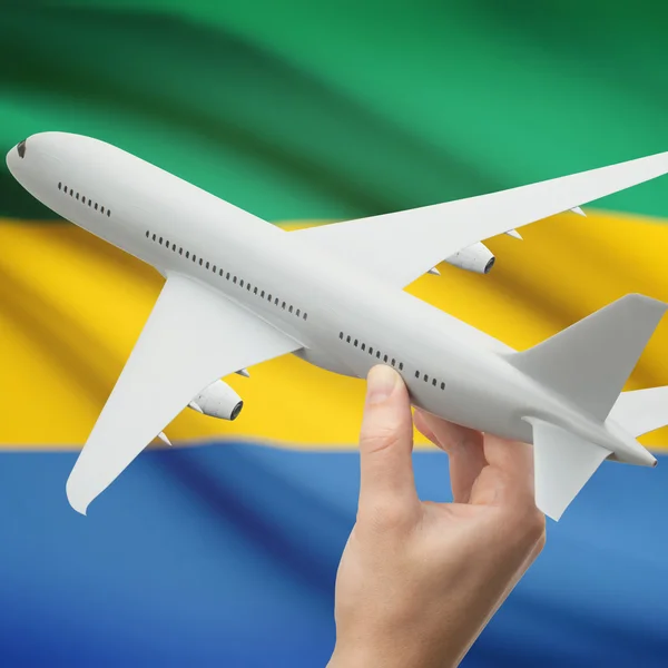 Samolot w rękę z flagi na tle serii - Gabon — Zdjęcie stockowe