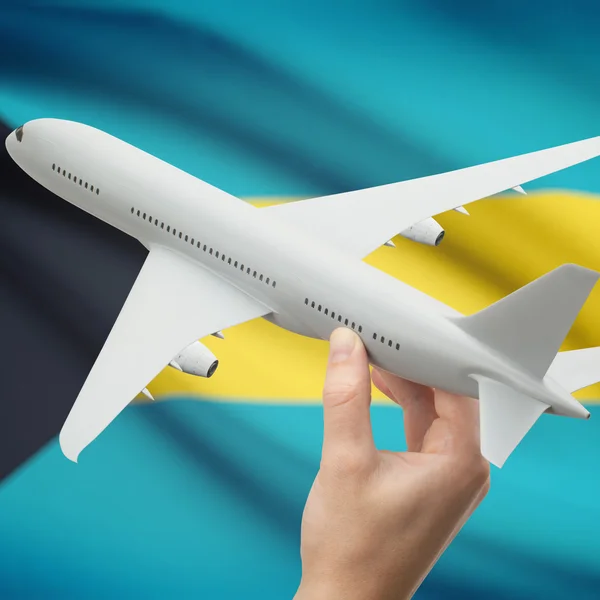 Flugzeug in der Hand mit Flagge auf Hintergrund-Serie - Bahamas — Stockfoto