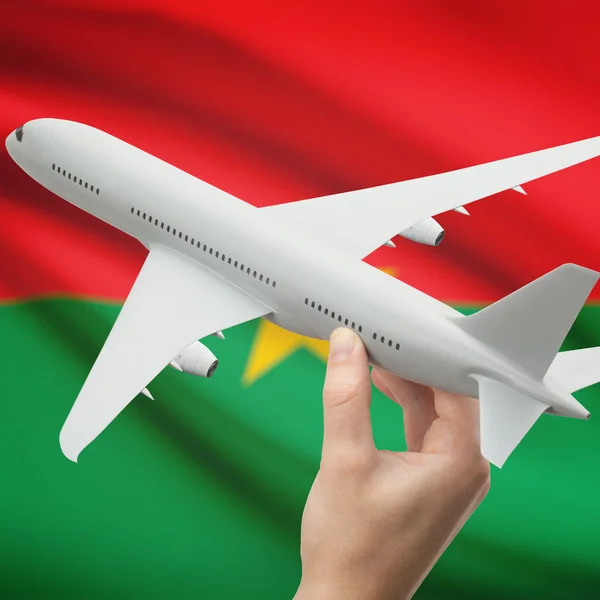 Airplane in hand with flag on background series - Burkina Faso — Stock Photo, Image