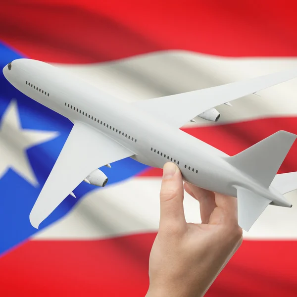 Vliegtuig in hand met vlag op achtergrond serie - Puerto Rico — Stockfoto