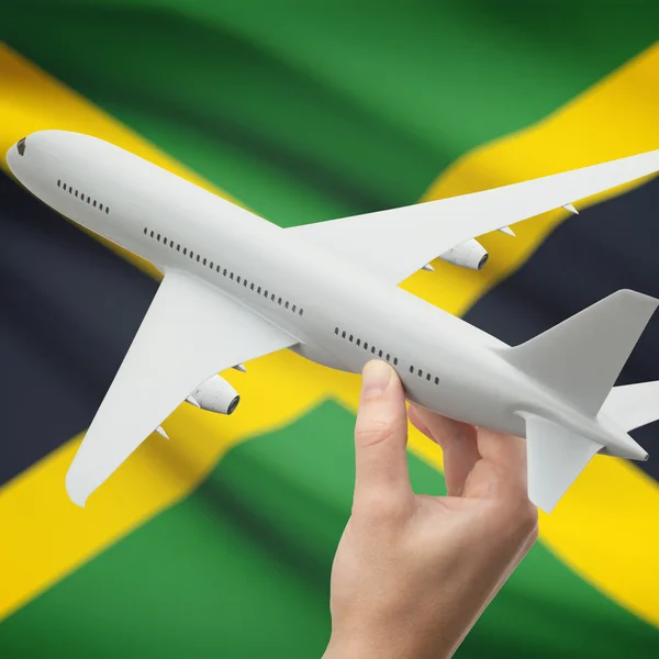 Airplane in hand with flag on background series - Jamaica — Stock Photo, Image