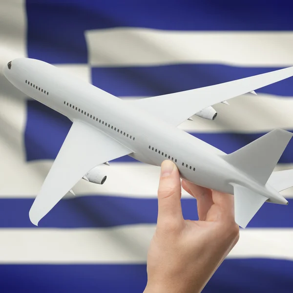 Airplane in hand with flag on background series - Greece — Stock Photo, Image