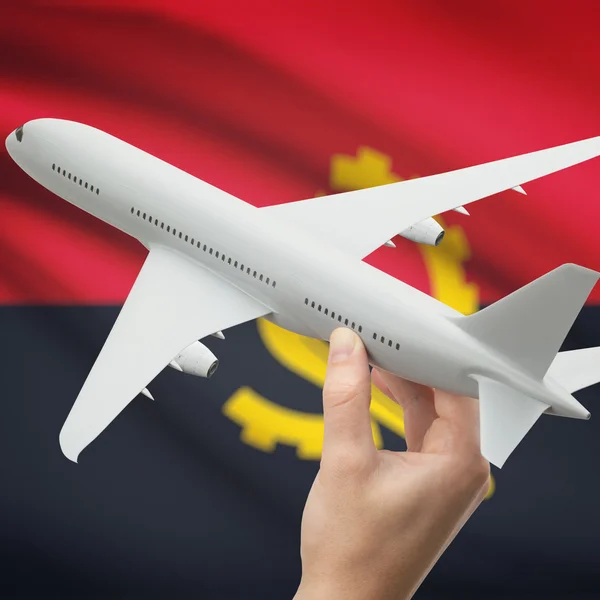 Avião na mão com a bandeira na série de fundo - Angola — Fotografia de Stock