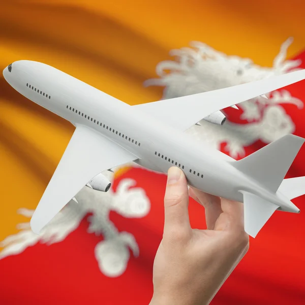 Flugzeug in der Hand mit Flagge auf Hintergrund-Serie - Bhutan — Stockfoto