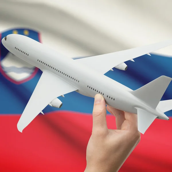 Airplane in hand with flag on background series - Slovenia — Stock Photo, Image