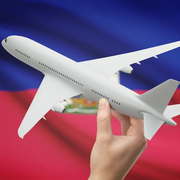 Avião na mão com a bandeira na série de fundo - Haiti — Fotografia de Stock