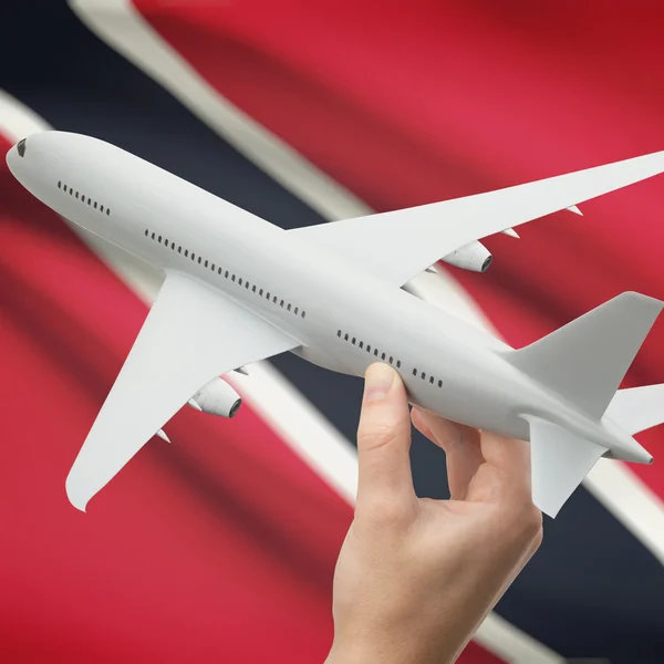 Flugzeug in der Hand mit Flagge auf Hintergrund-Serie - Trinidad und Tobago — Stockfoto