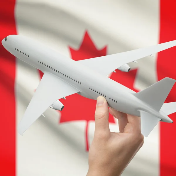 Самолет в руку с флагом на фоне серии - Канада — стоковое фото