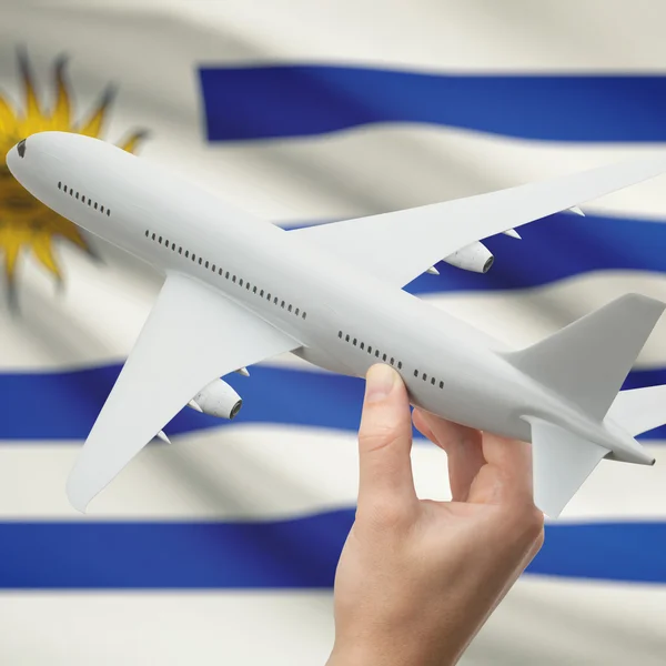 Airplane in hand with flag on background series - Uruguay — Stock Photo, Image