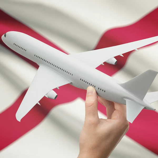 Airplane in hand with US state flag on background series - Alabama — Stock Photo, Image