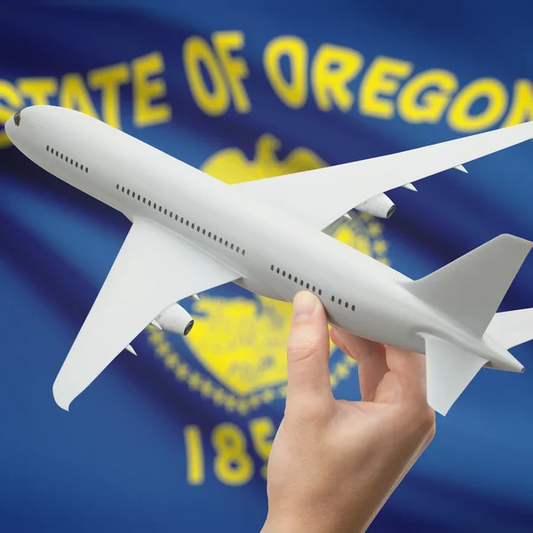 Airplane in hand with US state flag on background series - Oregon — Stok fotoğraf