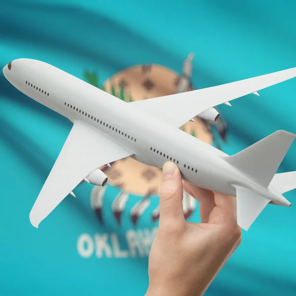 Самолет в руке с нами государственного флага на фоне серии - Оклахома — стоковое фото