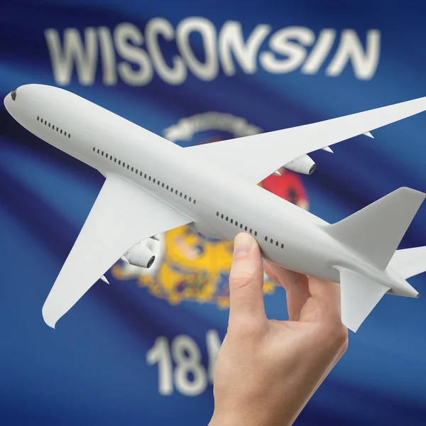 Avion dans la main avec nous drapeau d'état sur les séries de fond - Wisconsin — Photo