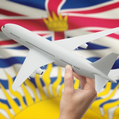 Airplane in hand with Canadian province flag on background series - British Columbia